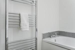 ein weißes Bad mit einem Waschbecken und einer Dusche in der Unterkunft Spacious 5-bed House Just Off A46 in Newark upon Trent