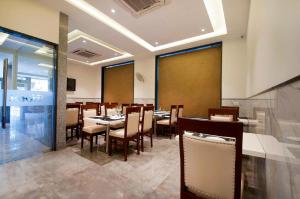 uma sala de jantar com uma mesa e cadeiras em Prime Z Suites Hotel- Near Delhi International Airport em Nova Deli