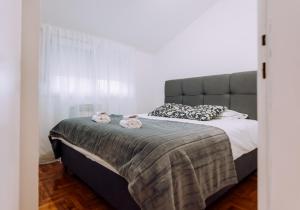 Un dormitorio con una cama grande con dos animales de peluche. en Apartment Sara en Zagreb