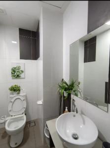 La salle de bains blanche est pourvue de toilettes et d'un lavabo. dans l'établissement Empire City M Tower, à Petaling Jaya