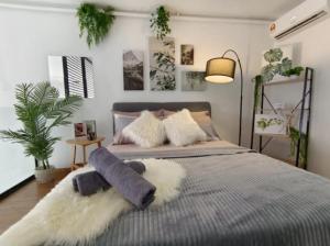 a bedroom with a bed with a blanket and a plant at Empire City M Tower in Petaling Jaya