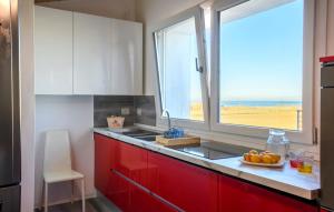 馬洛塔的住宿－piccolo chalet，一间厨房,配有红色橱柜和窗户