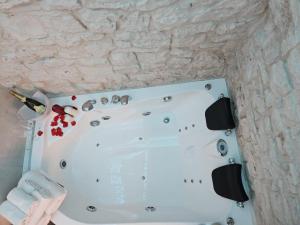 a white bath tub in a stone wall at LUXUITE Villa con Piscina e sauna o villa con jacuzzi e doccia emozionale in Alberobello