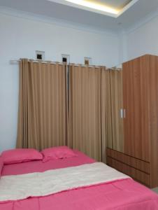 a bedroom with a bed and some curtains at Griya Delvin in Temon