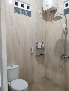 łazienka z toaletą i prysznicem w obiekcie Griya Delvin w mieście Temon