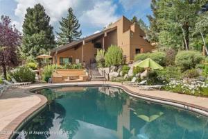 a house with a swimming pool in front of a house at New Listing Just renovated 3BR 3BA in Snowmass Village