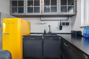 a kitchen with a sink and a yellow refrigerator at Aquamarina Onyx 84 in Międzyzdroje