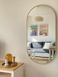 a living room with a mirror and a couch at .L'Armor. Appartement avec terrasse & parking in Les Sables-d'Olonne