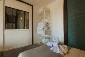 a room with a bed and a shelf with towels at Let's take a walk in the woods in Tours