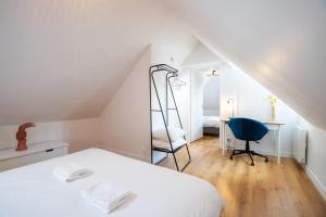 1 dormitorio con cama, escritorio y escalera en Comfort and modernity in a townhouse, en Tours