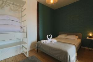 a bedroom with a bed with a heart decoration on it at Let's take a walk in the woods in Tours