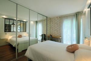 een slaapkamer met 2 bedden en een spiegelwand bij T3 in the heart of Jean Jaurès with free parking in Tours +4 foto's