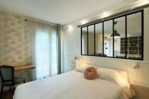 een slaapkamer met een groot wit bed met een spiegel bij T3 in the heart of Jean Jaurès with free parking in Tours