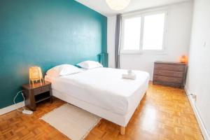 ein Schlafzimmer mit einem weißen Bett und einer blauen Wand in der Unterkunft Le Botanique - Joli appart à Tours in Tours