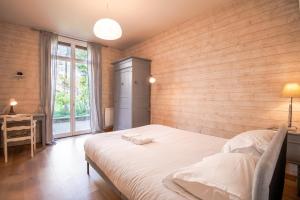 a bedroom with a large bed with a wooden wall at In the heart of silence - Nice house in Tours