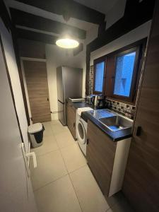 a small kitchen with a sink and a washing machine at Between old-world charm and modernity in Tours