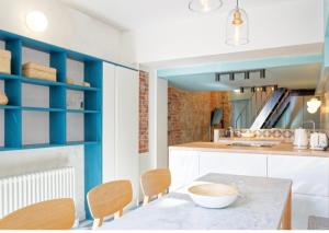 a kitchen with a table and chairs and blue shelving at Appartement Atypique Au Pied Du Sacré Cœur in Paris