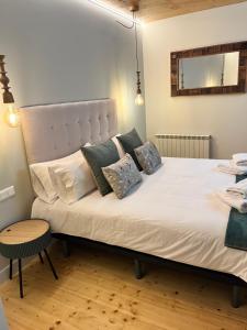 ein Schlafzimmer mit einem großen weißen Bett mit Kissen in der Unterkunft Can Bernades in Puigcerdà