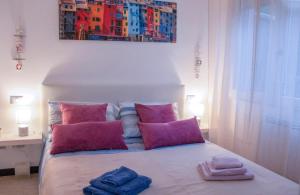 una camera da letto con un letto con cuscini rosa e un dipinto di la casa di gusto a La Spezia