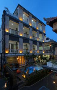 a building with a swimming pool in front of it at Lotus Tirta Seminyak in Seminyak