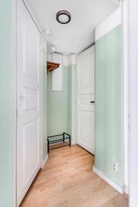 Centrum - Lovely furnished Studio في هلسنكي: ممر فارغ بأبواب بيضاء وأرضية خشبية