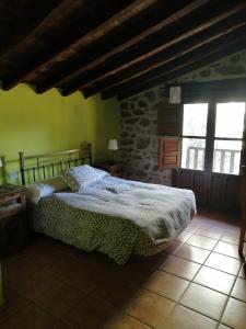 ein Schlafzimmer mit einem Bett und einer Steinmauer in der Unterkunft LA CASONA in Jaraiz de la Vera