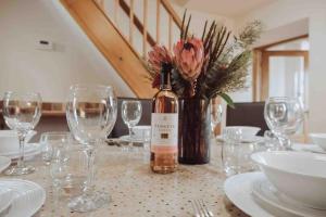 a table with a bottle of wine and wine glasses at Mabels Cottage, Longnor in Longnor
