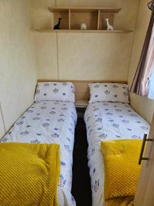 a small room with two beds in a trailer at J.R. Holiday Homes in Saint Osyth