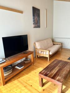ein Wohnzimmer mit einem Flachbild-TV und einem Sofa in der Unterkunft Can Bernades in Puigcerdà