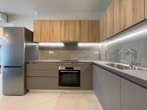 a kitchen with stainless steel appliances and a sink at Urban Oasis in Ellinikon - Athenean BnB in Athens