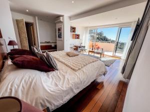 a bedroom with a large bed and a balcony at Cactus - Villa avec piscine, vue sublime, Salle de jeux - by TGB in Rayol-Canadel-sur-Mer