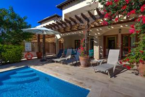 een villa met een zwembad en een huis bij 2 bedroom Apartment Eros with private pool and garden, Aphrodite Hills Resort in Kouklia