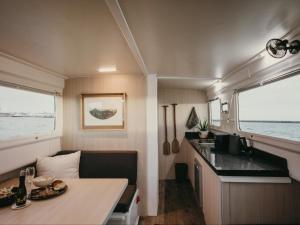 a small kitchen with a table in a trailer at Waterfront Houseboat in Cape Town