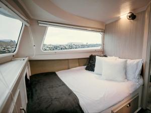 Kleines Zimmer mit einem Bett und einem Fenster in der Unterkunft Waterfront Houseboat in Kapstadt
