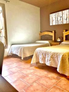 a bedroom with two beds and a tile floor at Casa Parranxo in Senterada