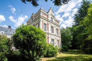 un grand bâtiment blanc avec une tour en haut dans l'établissement Castle life at Saint-Benoît-la-Forêt, à Saint-Benoît-la-Forêt