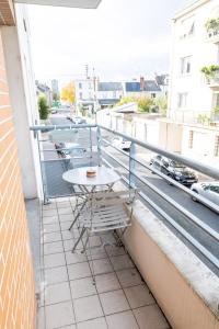 a table and chairs on the balcony of a building at Pastel colors - Tours in Tours