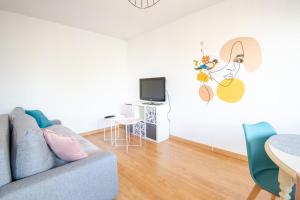 a living room with a couch and a tv at Pastel colors - Tours in Tours