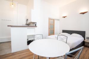 twee bedden in een kamer met een tafel en stoelen bij My white paradise - fully equipped apartment in Tours