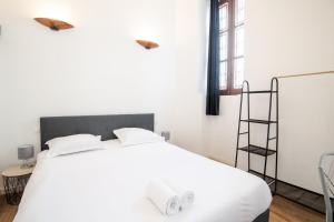 een slaapkamer met een wit bed met witte kussens bij My white paradise - fully equipped apartment in Tours