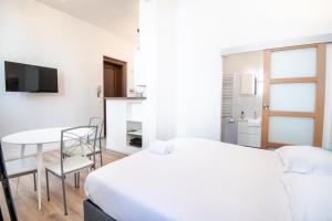 een slaapkamer met een wit bed en een tafel en stoelen bij My white paradise - fully equipped apartment in Tours