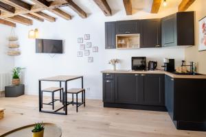 a kitchen with black cabinets and a table at Let's get some height in Tours