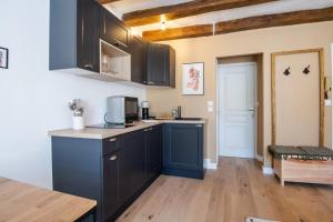 a kitchen with black cabinets and a wooden floor at Let's get some height in Tours