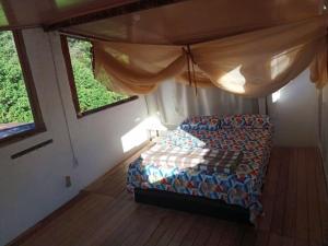 パウメイラスにあるCasa Quaresmeiraの窓付きの部屋にソファ付きのベッドルームがあります。