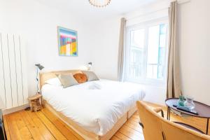 una camera da letto con un letto, un tavolo e una finestra di Le Petit Amandier - Tours a Tours