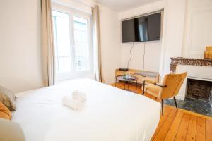 una camera da letto con un letto bianco e un camino di Le Petit Amandier - Tours a Tours Altre 4 foto