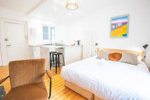 una camera da letto bianca con un letto e una sedia di Le Petit Amandier - Tours a Tours