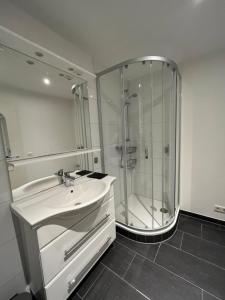 a white bathroom with a shower and a sink at Fürstenwall Suite in Düsseldorf
