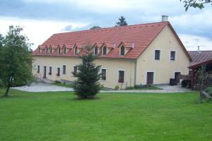 Srnín的住宿－克魯姆洛夫旅館，一座大型白色房屋,设有红色屋顶