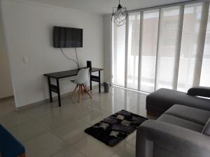 sala de estar con sofá y mesa con TV en Apartamento Laureles, en Medellín